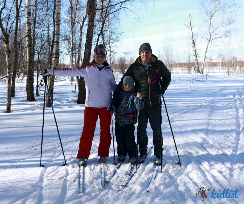 mom, dad, and child posing for a picture while cross-country skiing