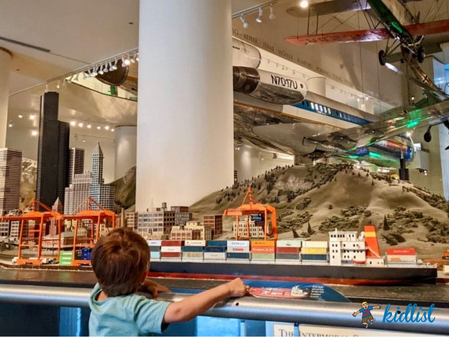 Child watches a model train go by at the Museum of Science and Industry.