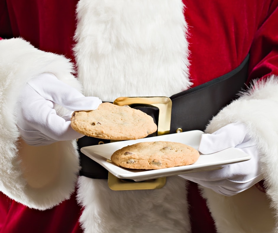 Santa holding out cookies for kids at a breakfast with Santa event