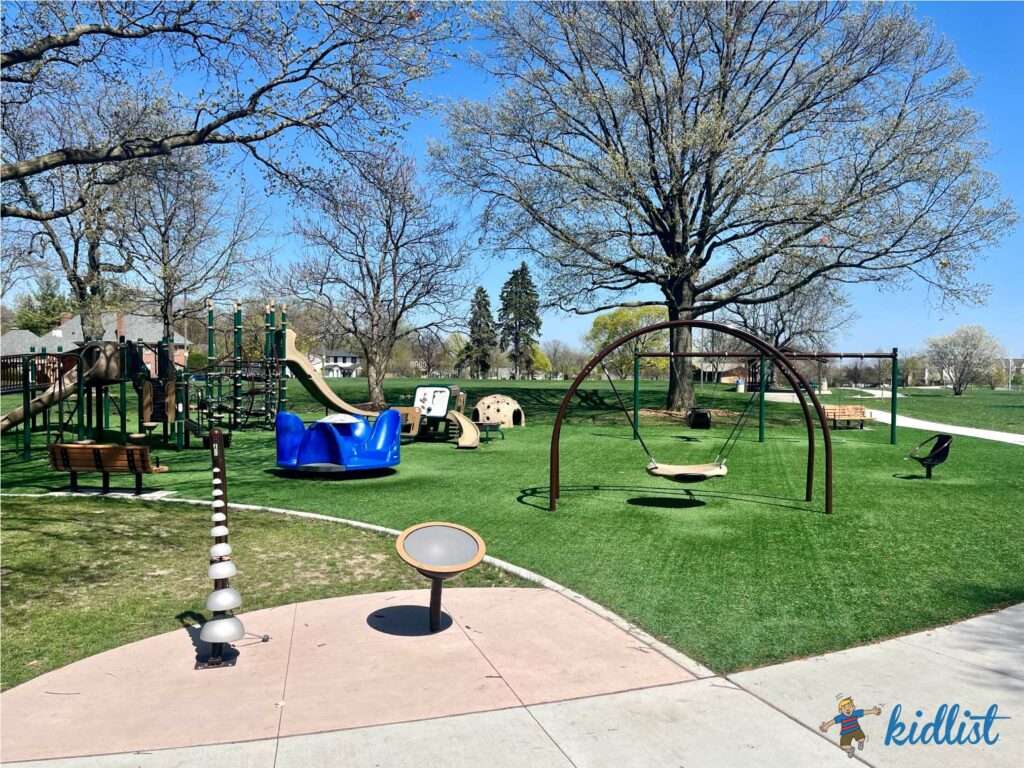 Newtown Park in Glen Ellyn's playground with a music station, saucer swing, merry-go-round, and play structures.