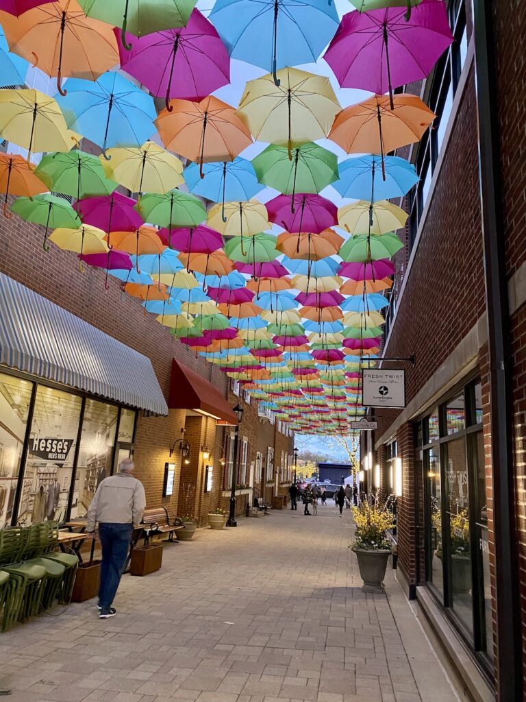 immersive experience with umbrellas hung next to each other over Schiller Court in Elmhurst with light streaming through the fabric
