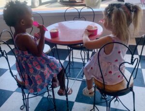 Kids sitting at a table eating ice cream in an ice cream parlor.