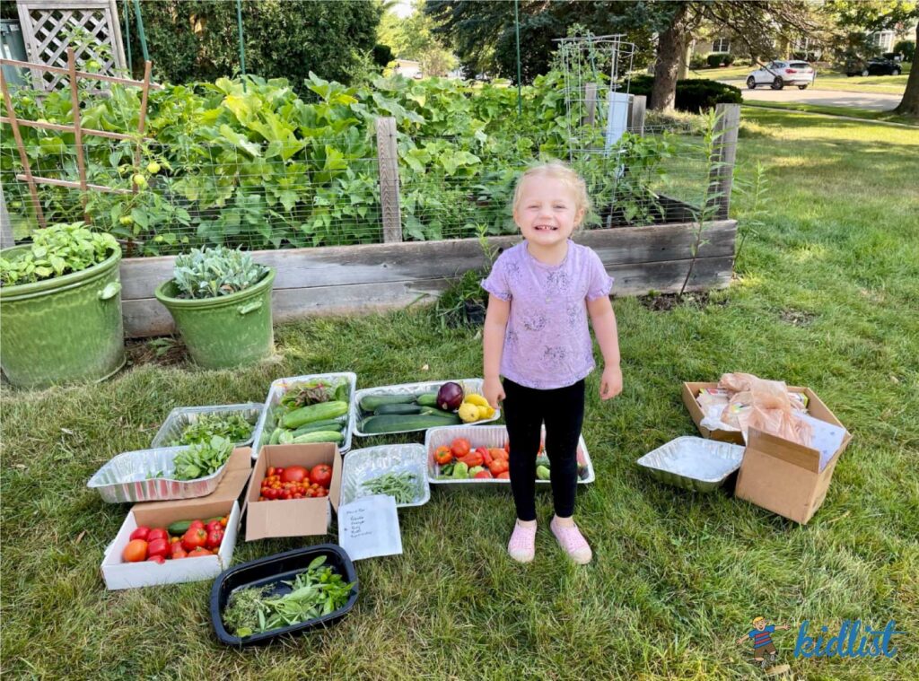 girl standing next to vegetables she gathering during volunteer opportunities for kids