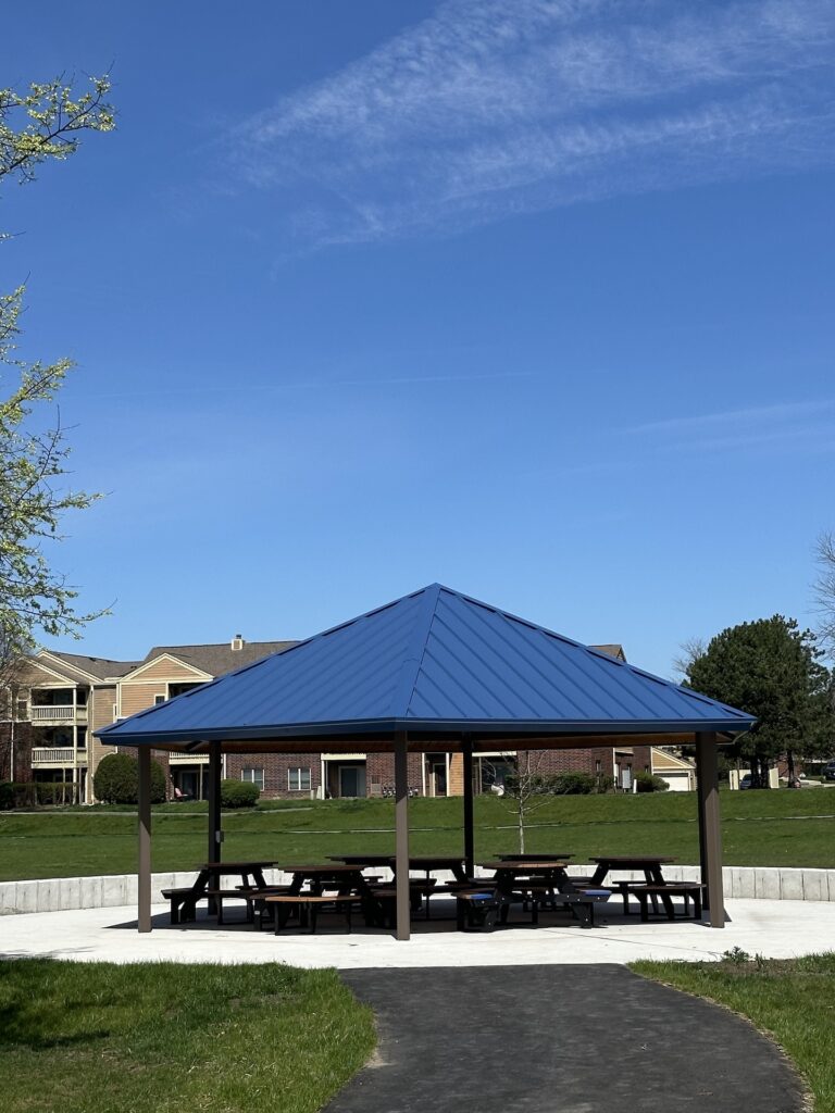 Shaded pavilion with about six picnic tables beneath at Stratford Park.