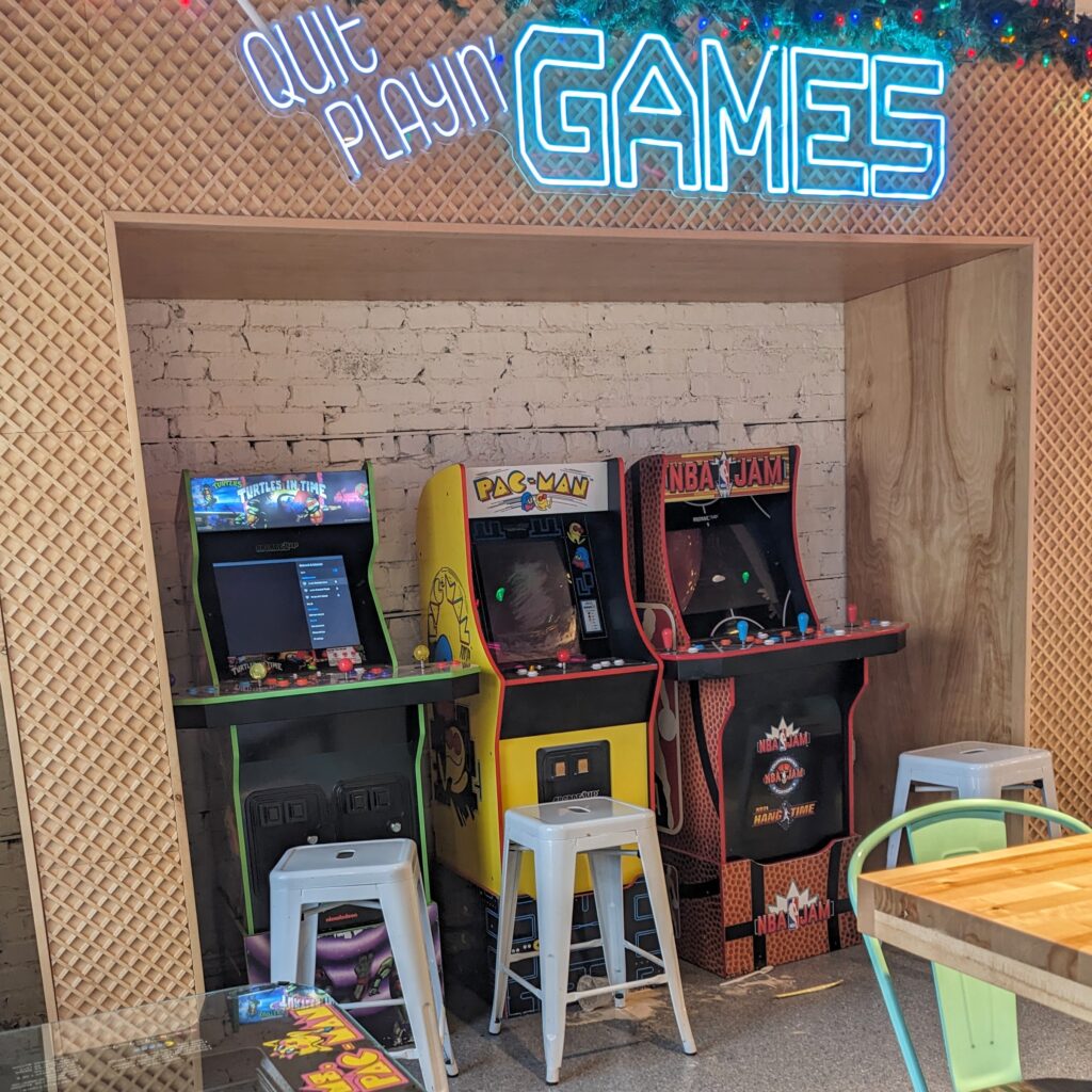 Three arcade games by dining tables at JoJo's in Naperville.