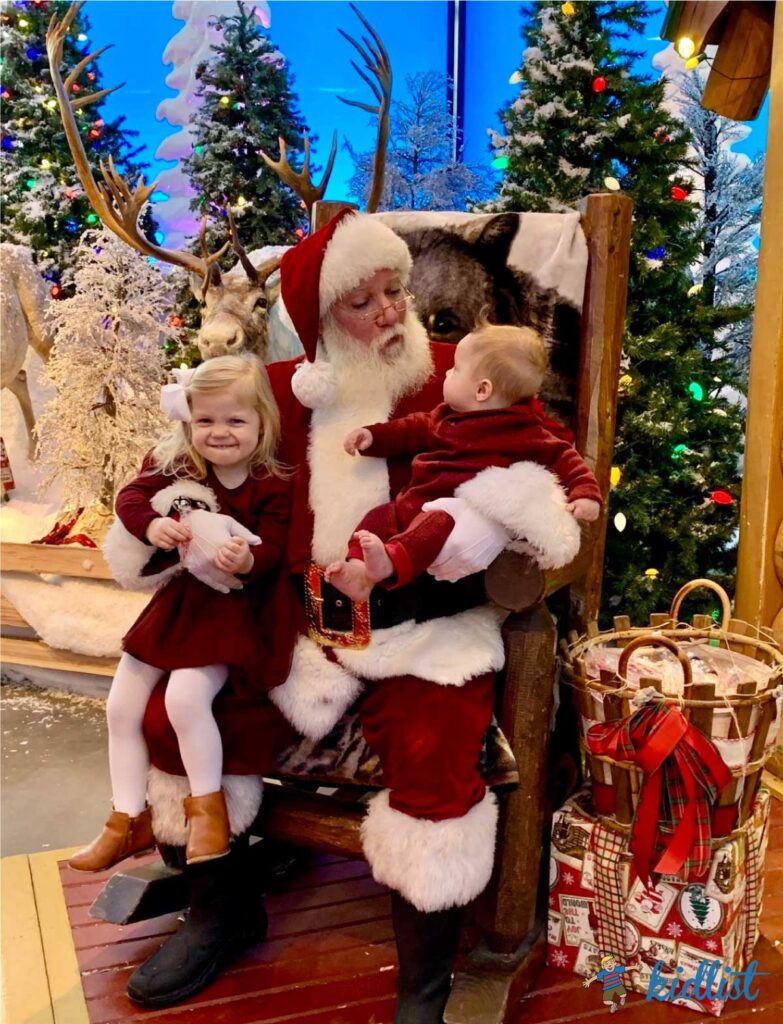 two kids getting pictures with Santa at Bass Pro Shop