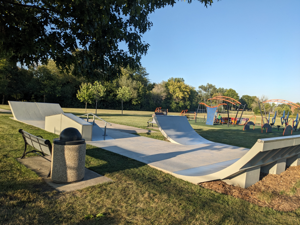 A couple of small permanent skate ramps, plus a bar, with a challenge course in the background.