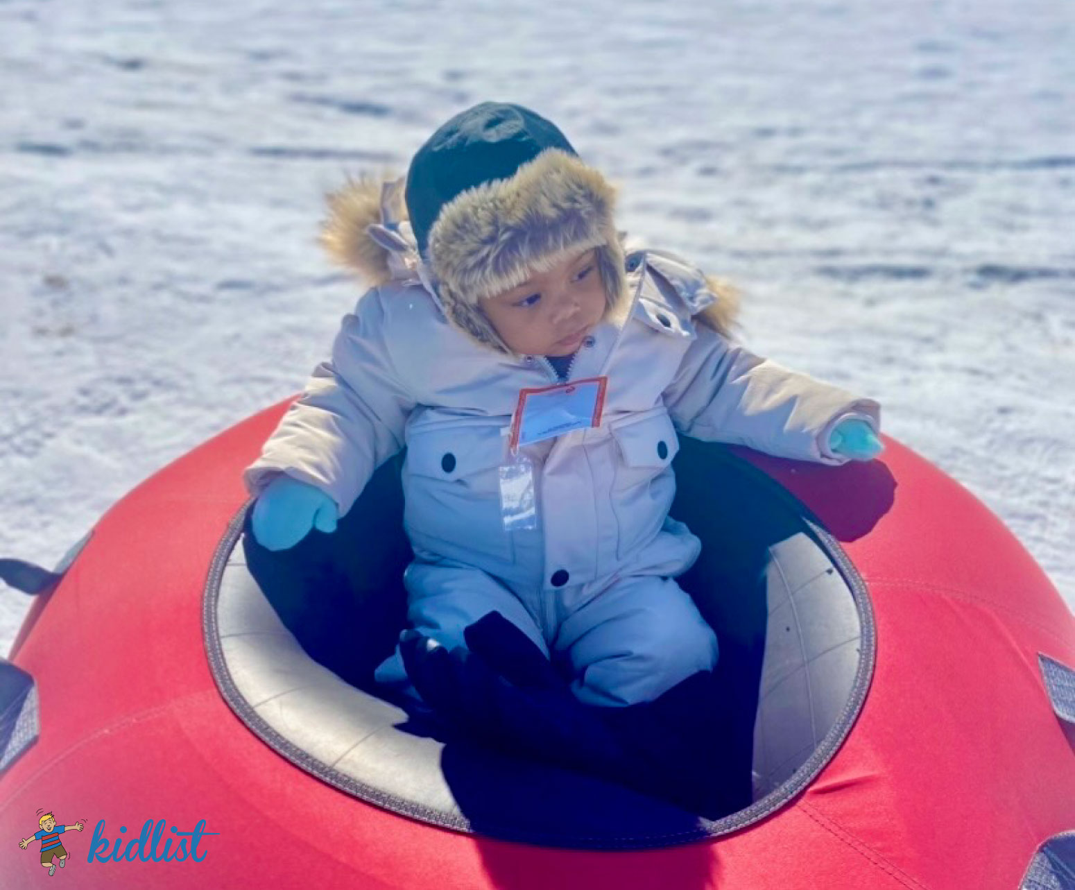 baby in a tube showing snow tubing as one of the most fun winter activities